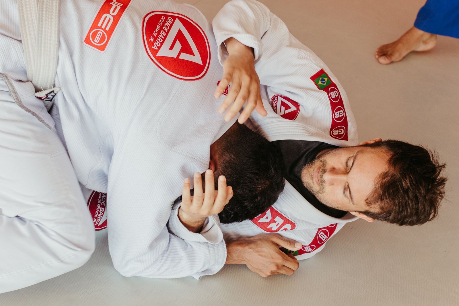 Grappler gripping gi during BJJ training after jammed finger treatment and recovery