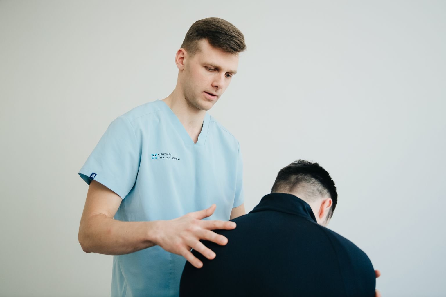 Physiotherapist assessing a patient's torso for floating rib pain
