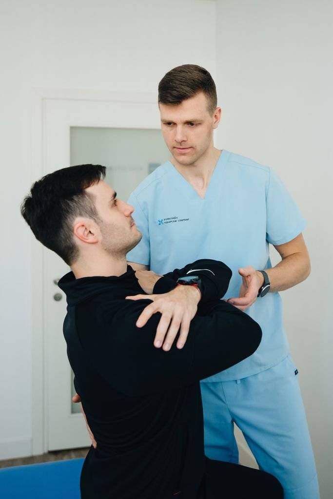 Physiotherapist assisting a patient with a therapeutic exercise for inside knee pain