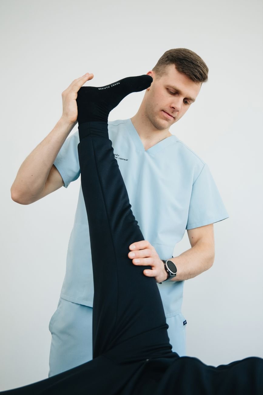 Physiotherapist guiding a patient through a calf strain recovery exercise