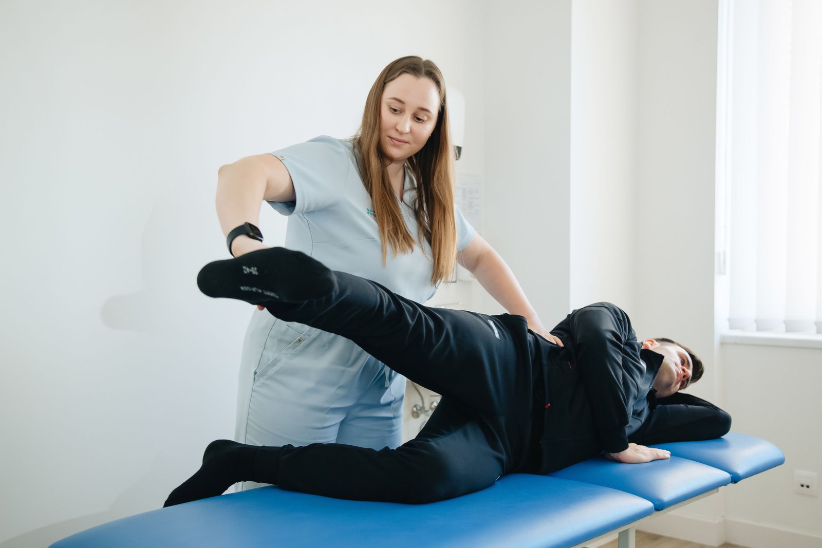 Physiotherapist guiding hip stretch as part of hip flexor strain symptoms recovery