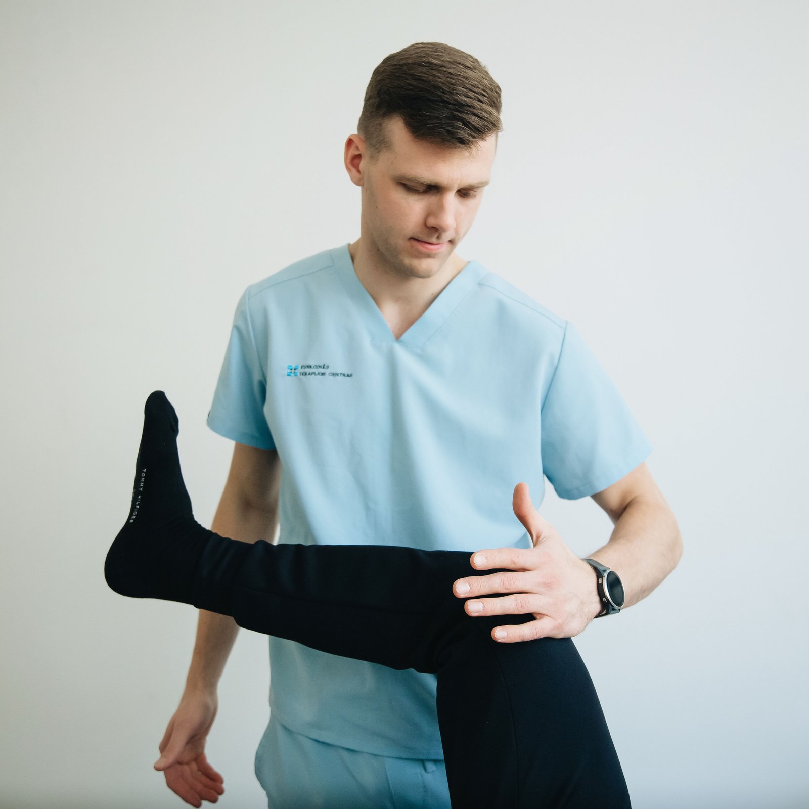 Clinician testing knee joint stability to assess a torn ligament