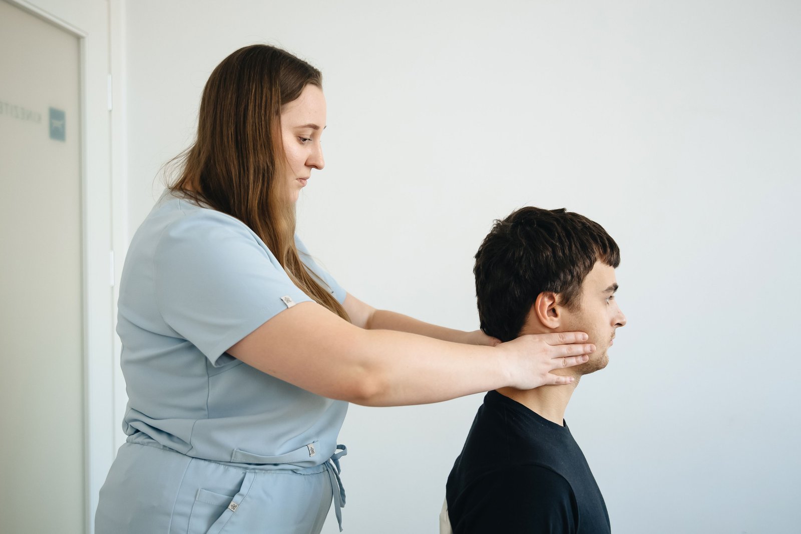 Therapist assessing neck and base of skull pain in a clinical setting