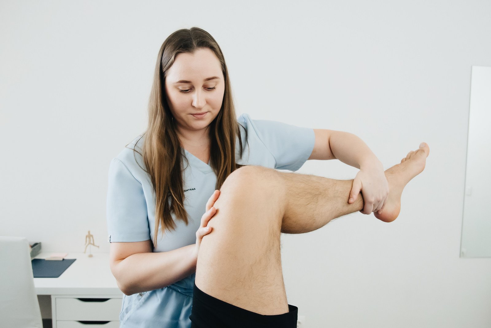 Clinician assessing an athlete's thigh for a quad strain after a sprinting injury