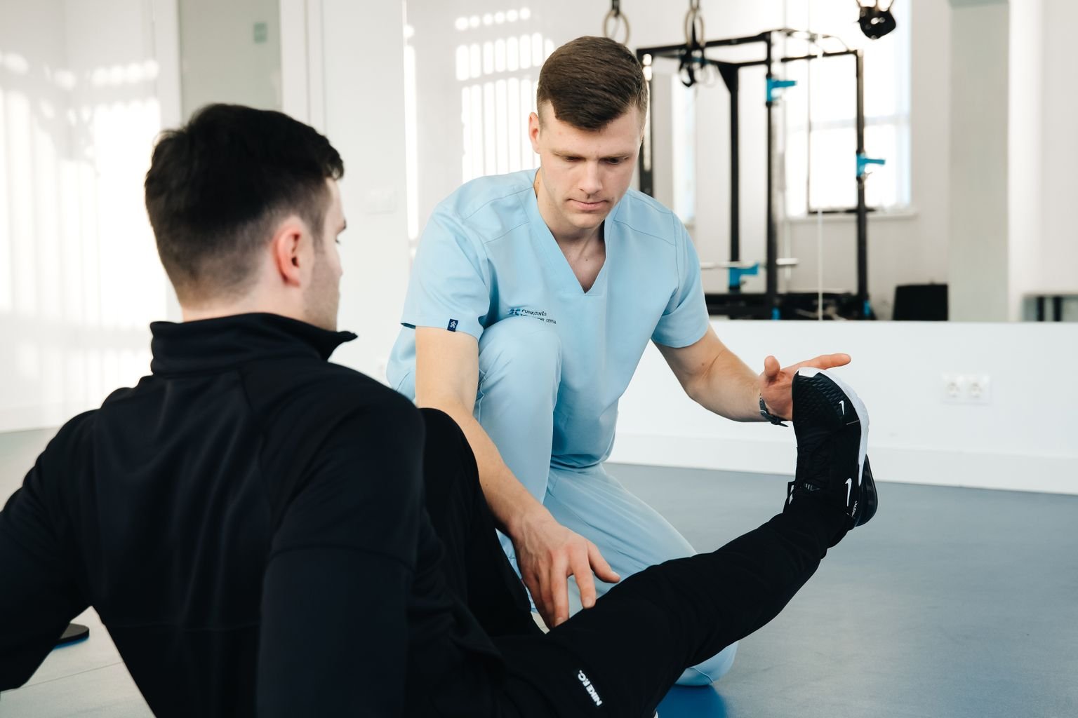 Physiotherapist guiding a patient through a leg exercise for lcl pain recovery