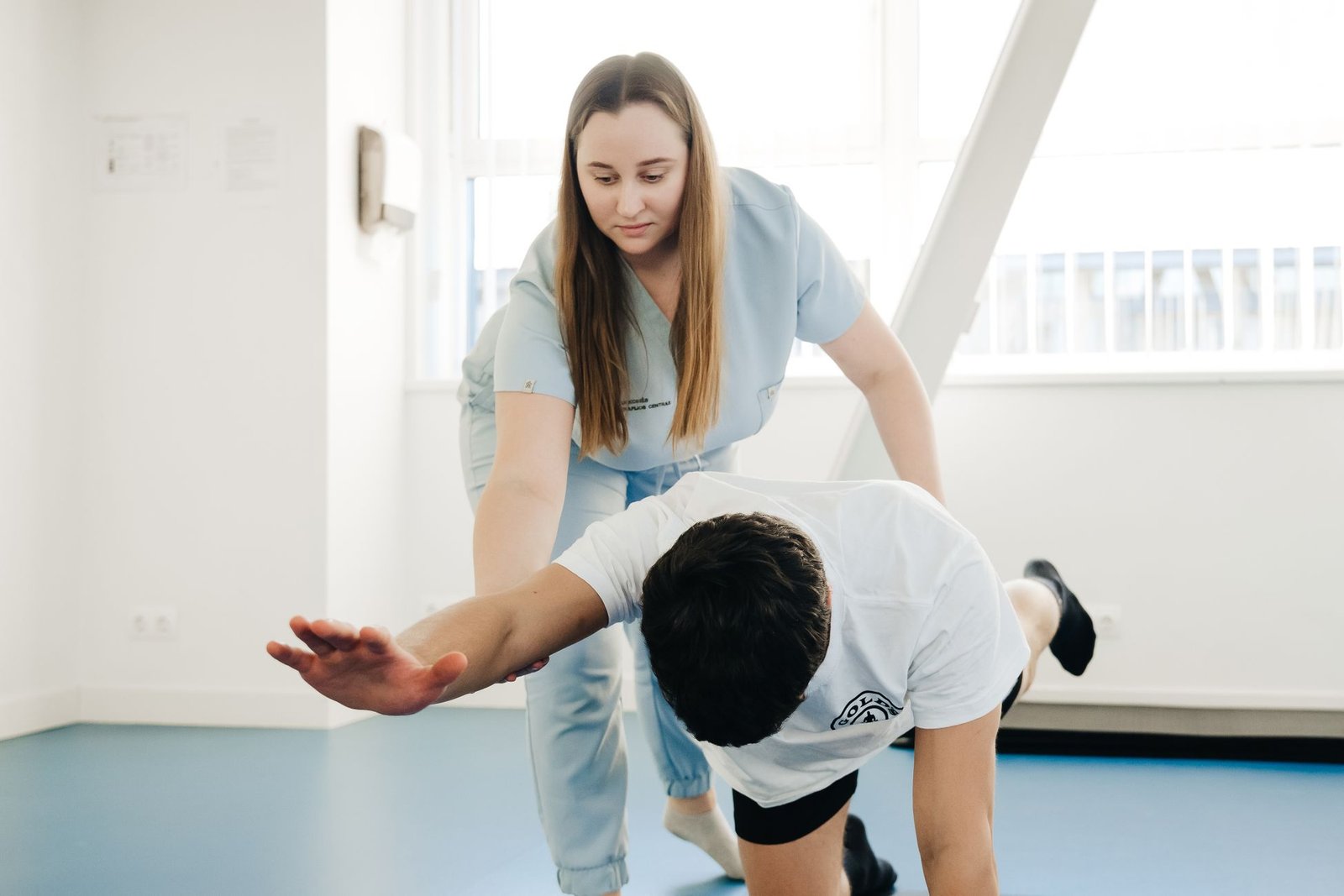 Physiotherapist guiding a thigh stretch as part of managing osgood-schlatter disease