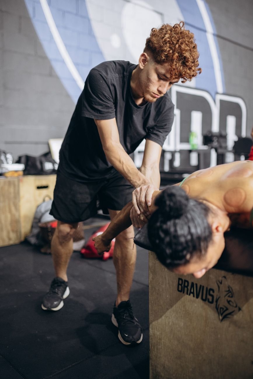 Therapist guiding shoulder mobility exercise after torn rotator cuff symptoms