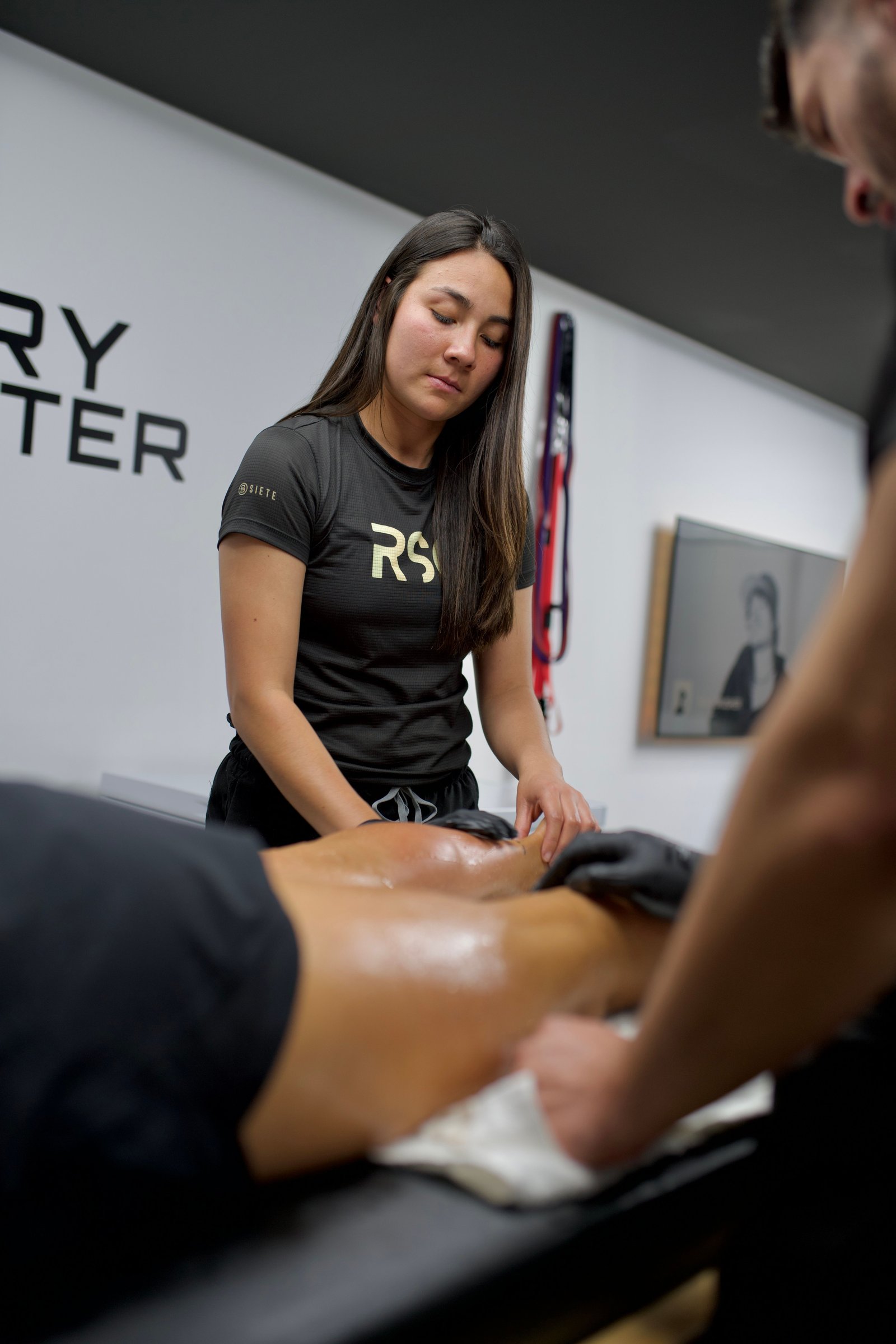 Therapist providing a sports massage as part of a muscle recovery plan