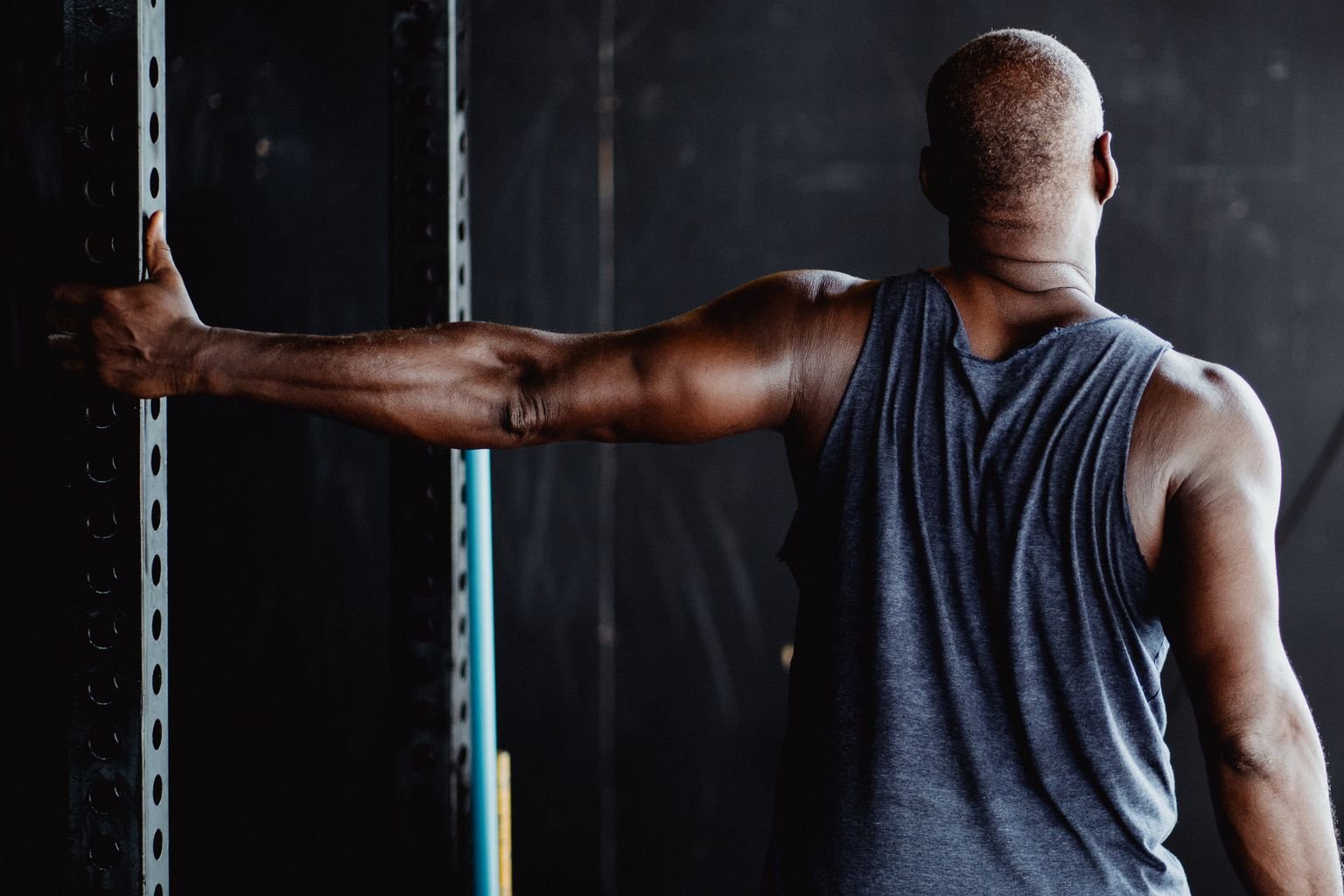 Person stretching their upper back for rhomboid pain relief