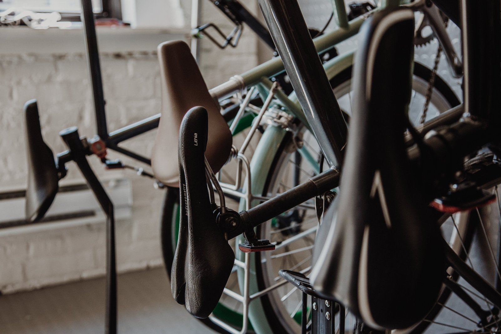 Cyclist adjusting saddle position to reduce tailbone pain while riding