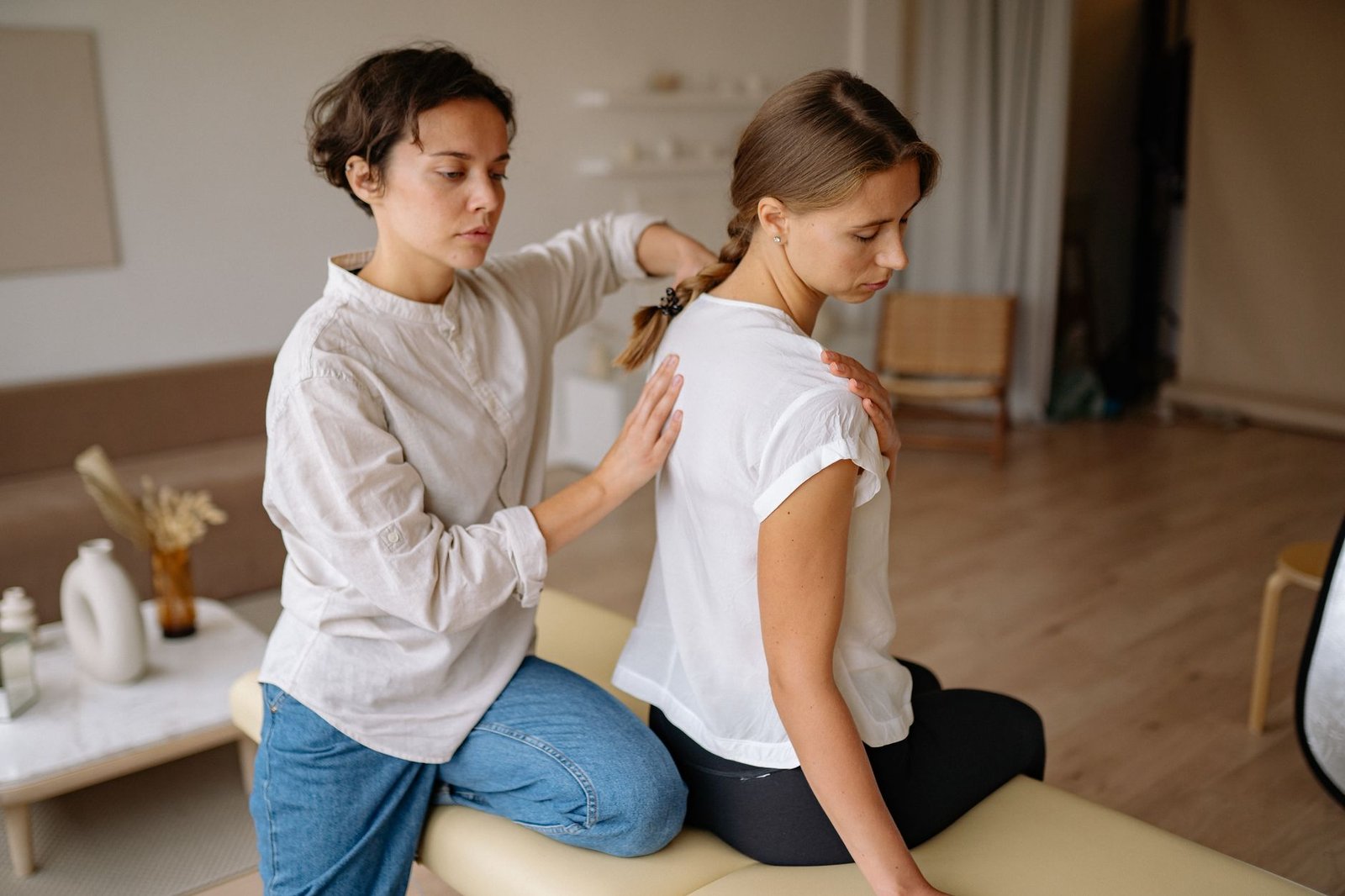 Therapist treating rhomboid muscle pain with hands-on upper back massage