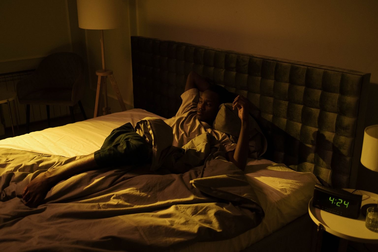 Person lying awake at night, unable to sleep with sciatica pain