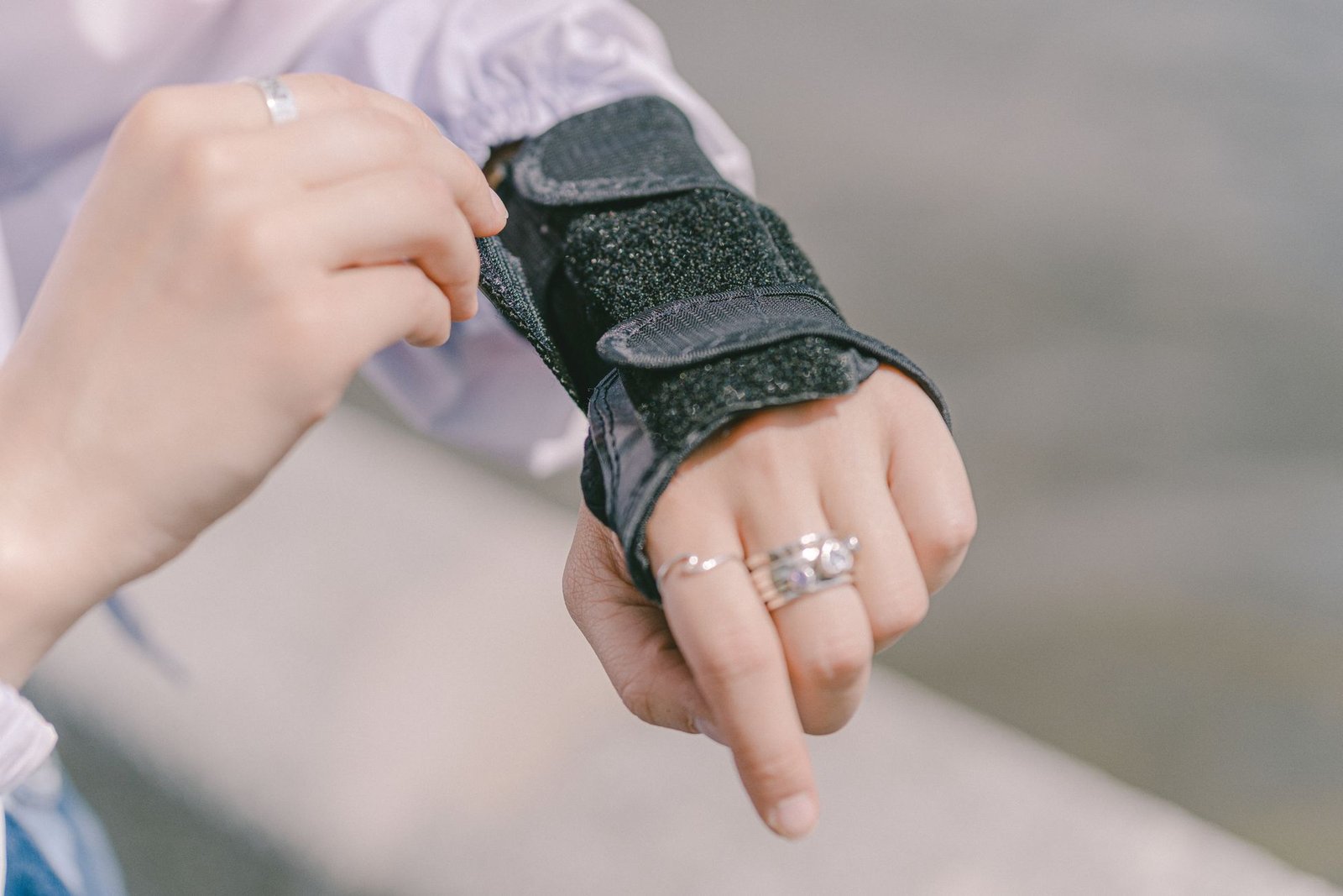 Wrist brace being adjusted for support during wrist sprain recovery