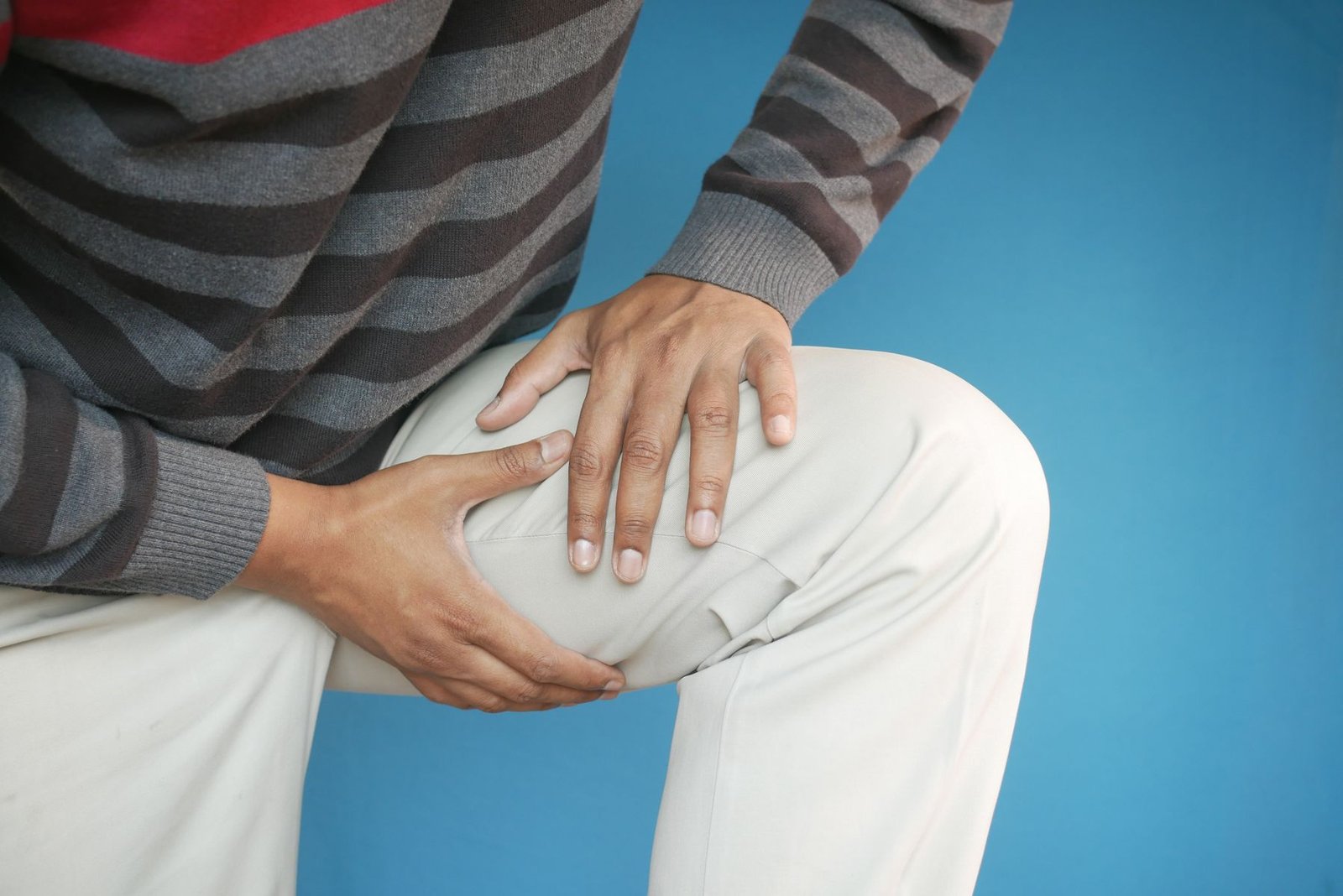 Person holding their knee, relevant to early steps in how to make your mcl heal faster