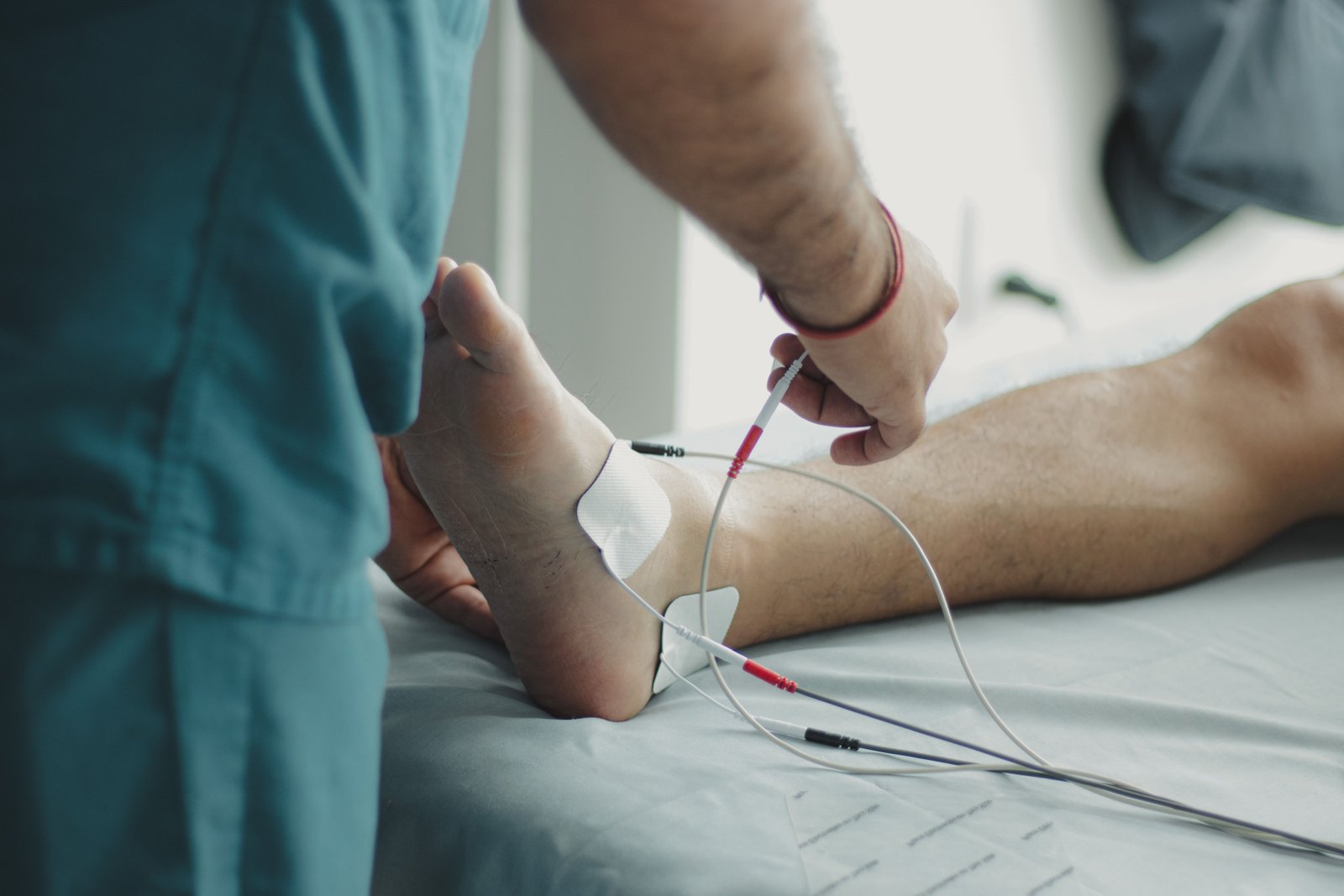 Clinician examining the lower leg to confirm a fibula stress fracture