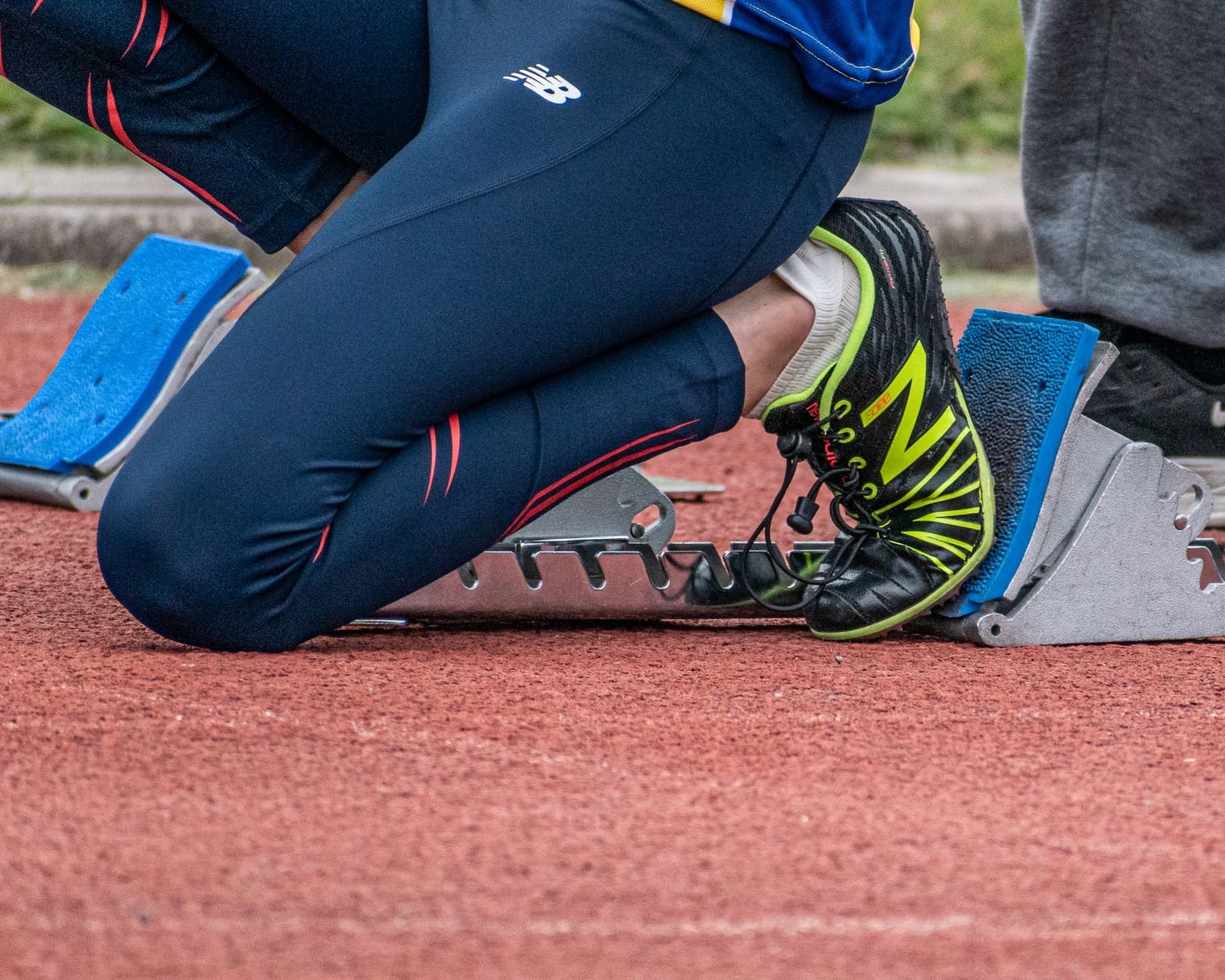 Runner in starting blocks, illustrating the explosive movement often linked to a quadriceps strain