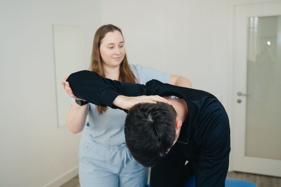 A physiotherapist guiding a patient through a shoulder exercise as part of dislocated shoulder recovery.