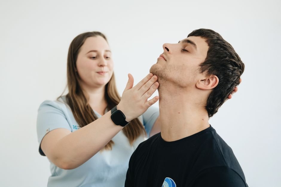 Physiotherapist assessing neck mobility after a guillotine BJJ related strain