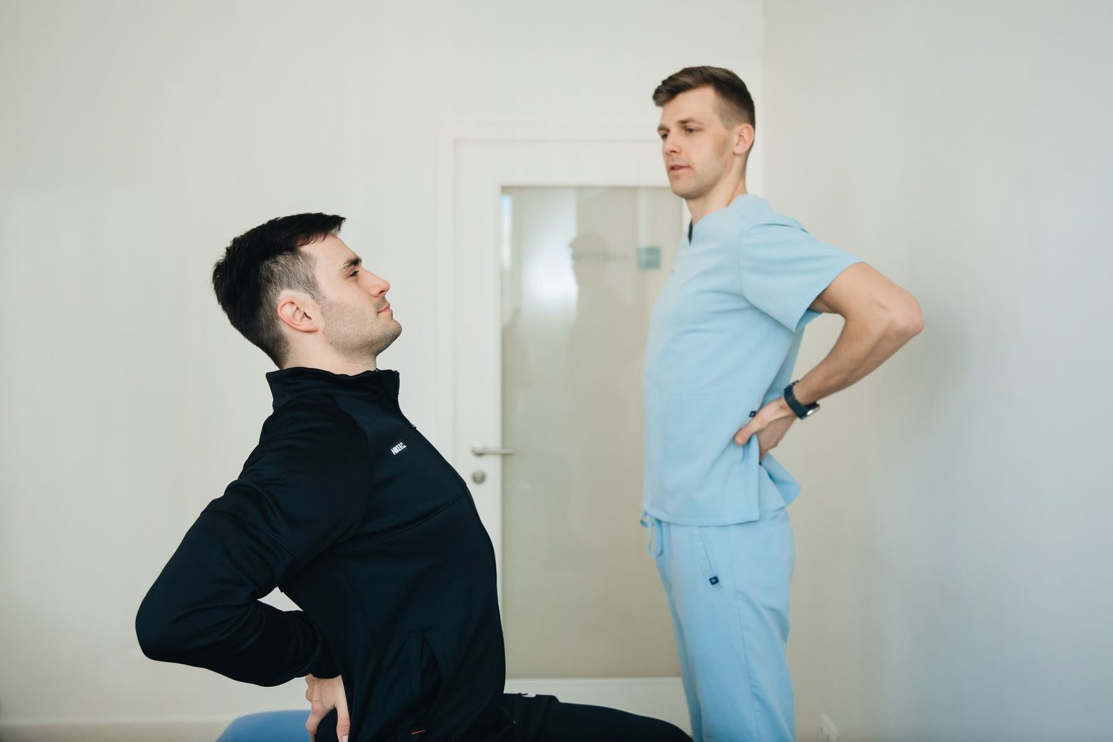 Physiotherapist guiding a client through back exercises, part of ql strain recovery