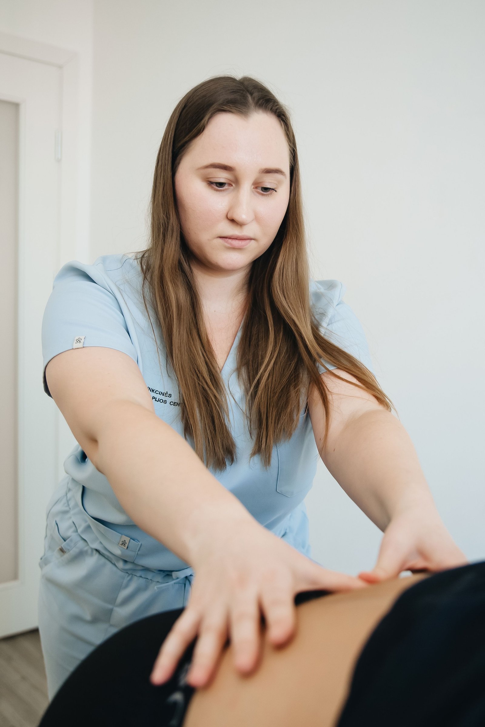 Physiotherapist providing treatment that speeds up safe recovery from a back strain