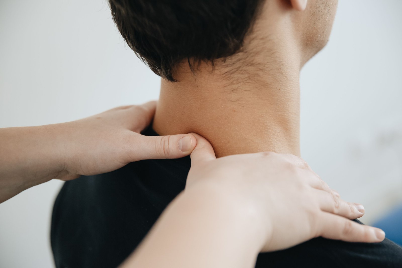 Physiotherapist treating neck tension contributing to pain on top of skull