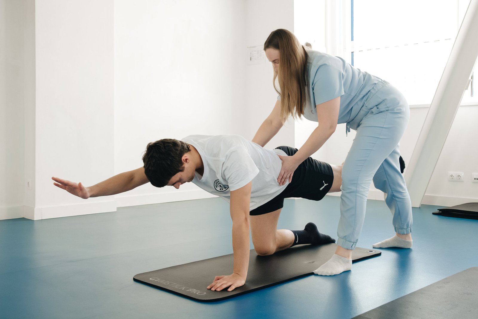 Physiotherapist guiding a patient through a rehab exercise during ACL recovery time