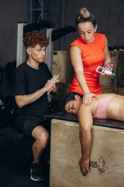 Sports massage therapist working on a client's shoulder muscles