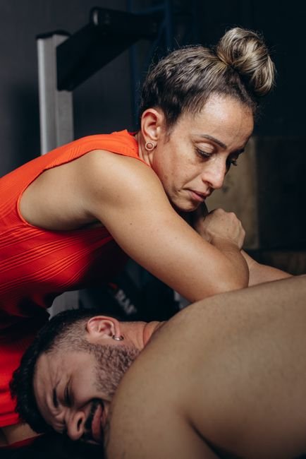 Therapist applying deep tissue massage pressure to a client's upper back