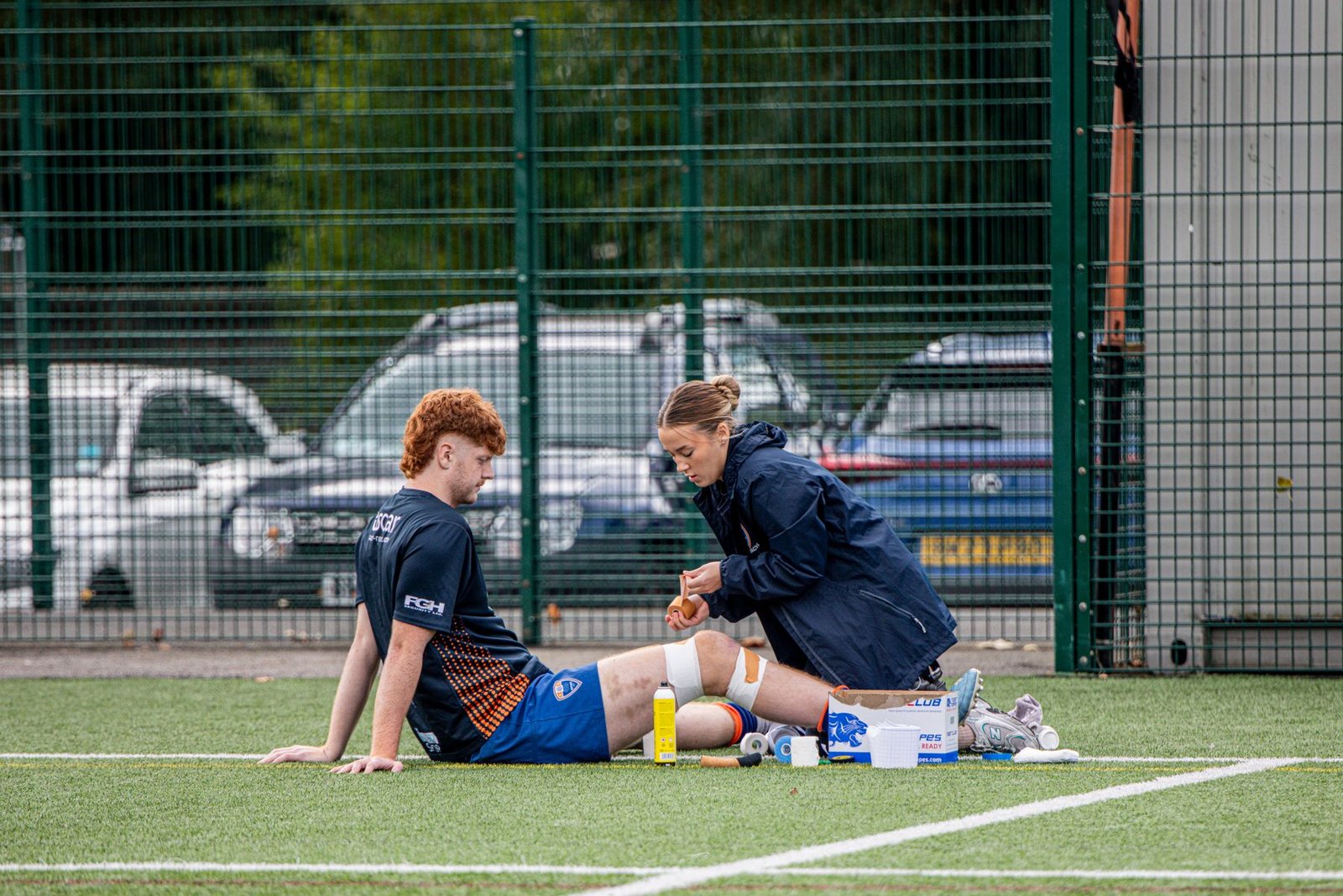 Sports therapist assessing a knee injury pitchside, relevant to identifying lcl injury symptoms