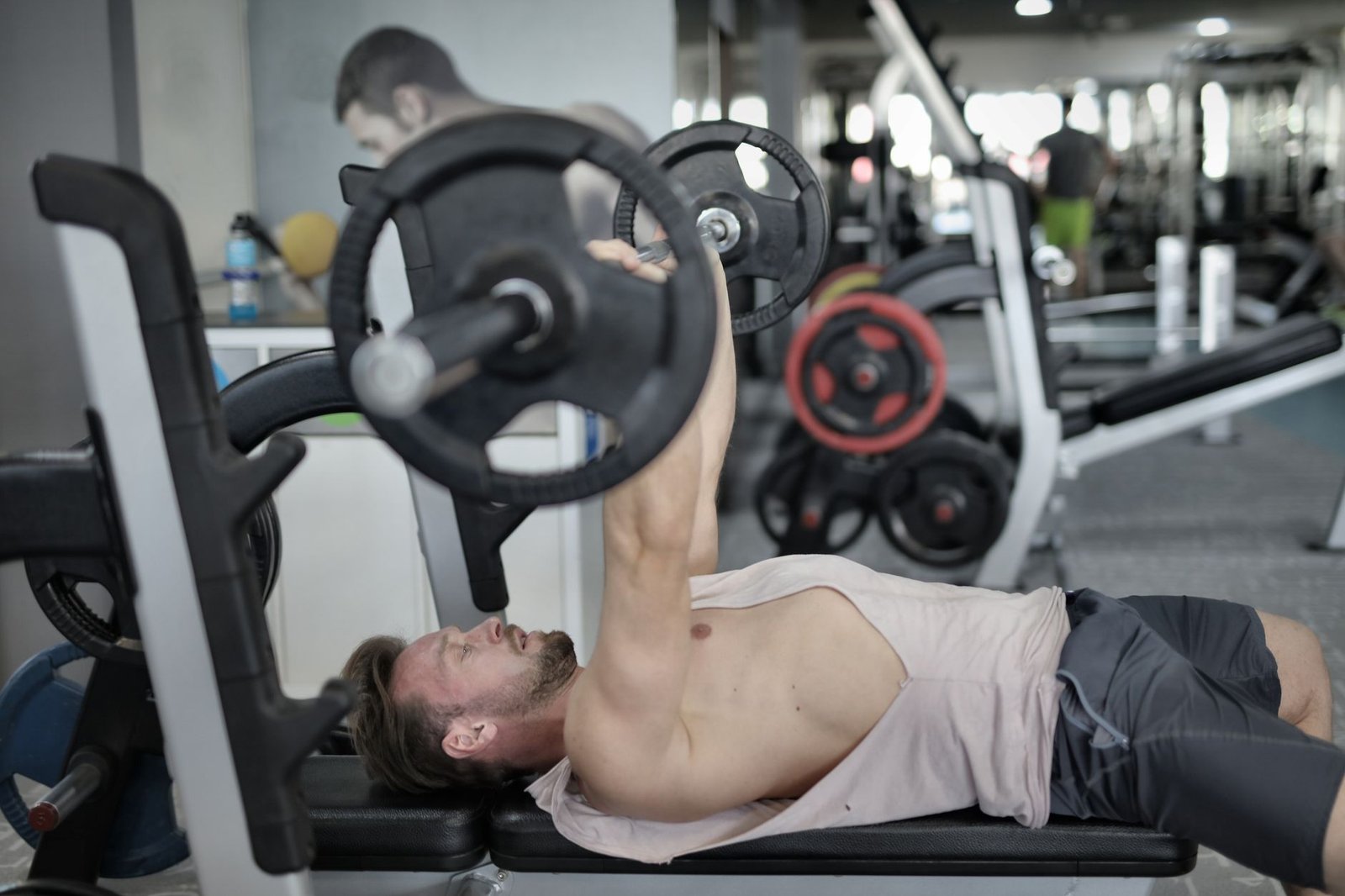 Person performing bench press form technique relevant to pec strain prevention
