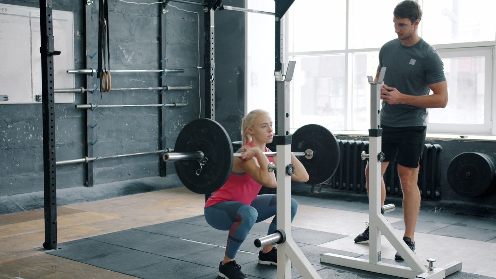 Demonstrating the inward knee movement, or valgus stress, involved in common MCL exercises to avoid during recovery.