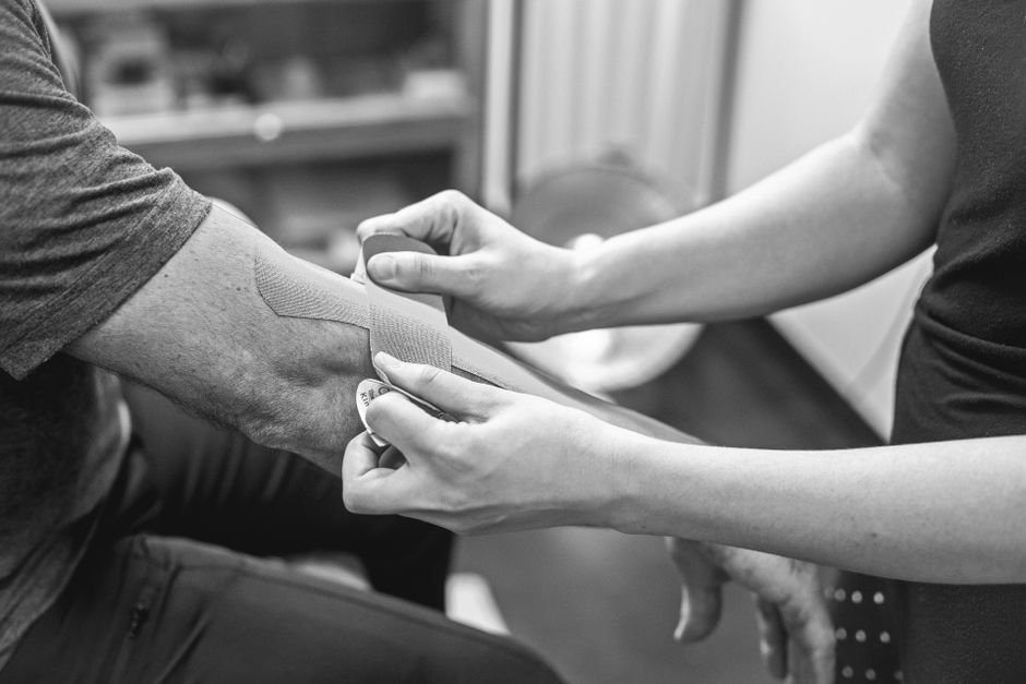 Kinesiology tape applied to a patient's elbow as part of armbar injury recovery