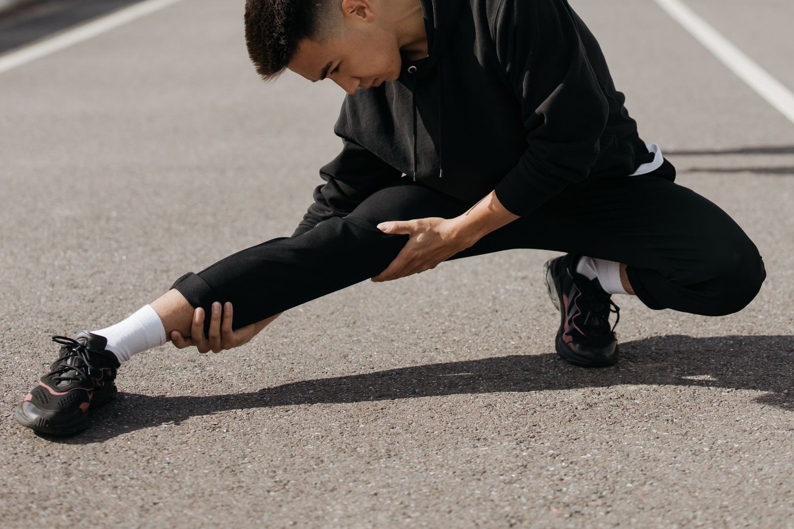 Person stretching their calf outdoors, an early step often paired with an achilles tendinopathy rehab protocol