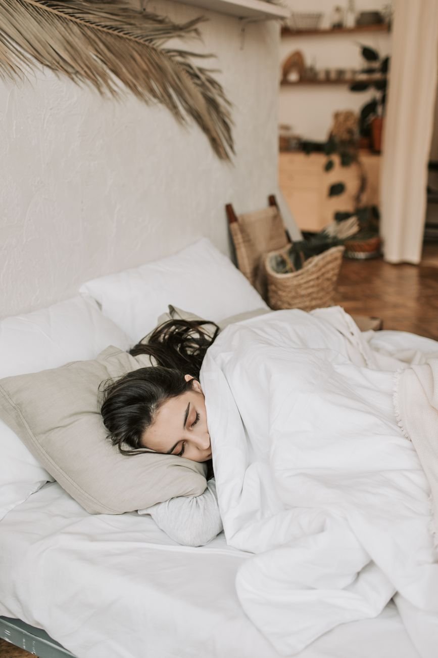 Person in a side sleeping position with pillow support for the best way to sleep with sciatica