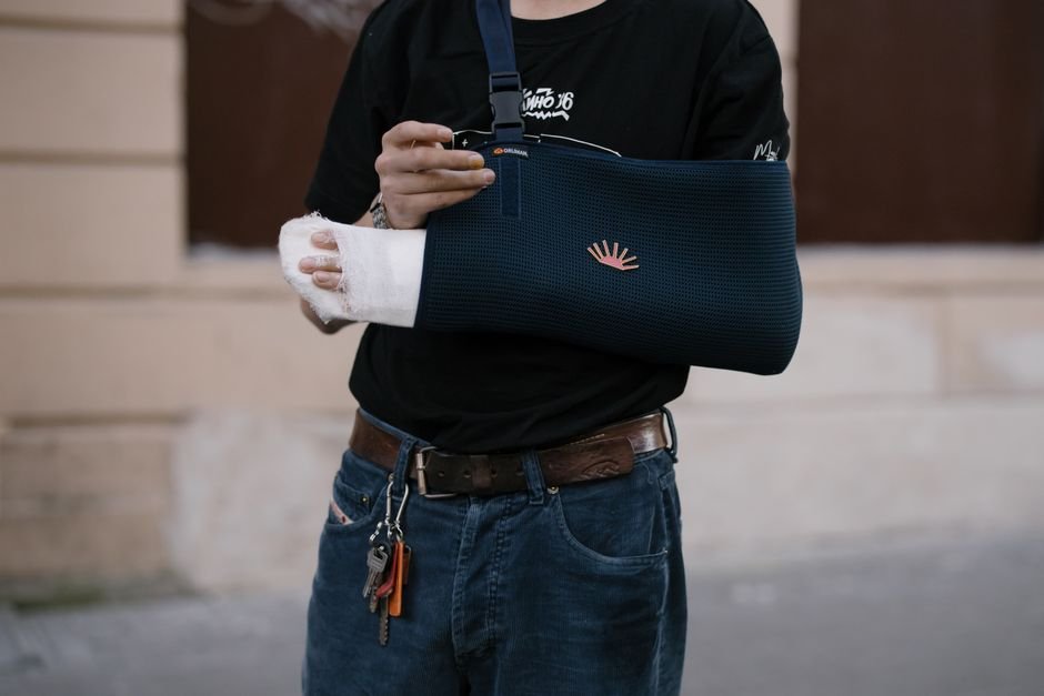 A person wearing a shoulder sling following a dislocated shoulder, part of the early protection phase of recovery.