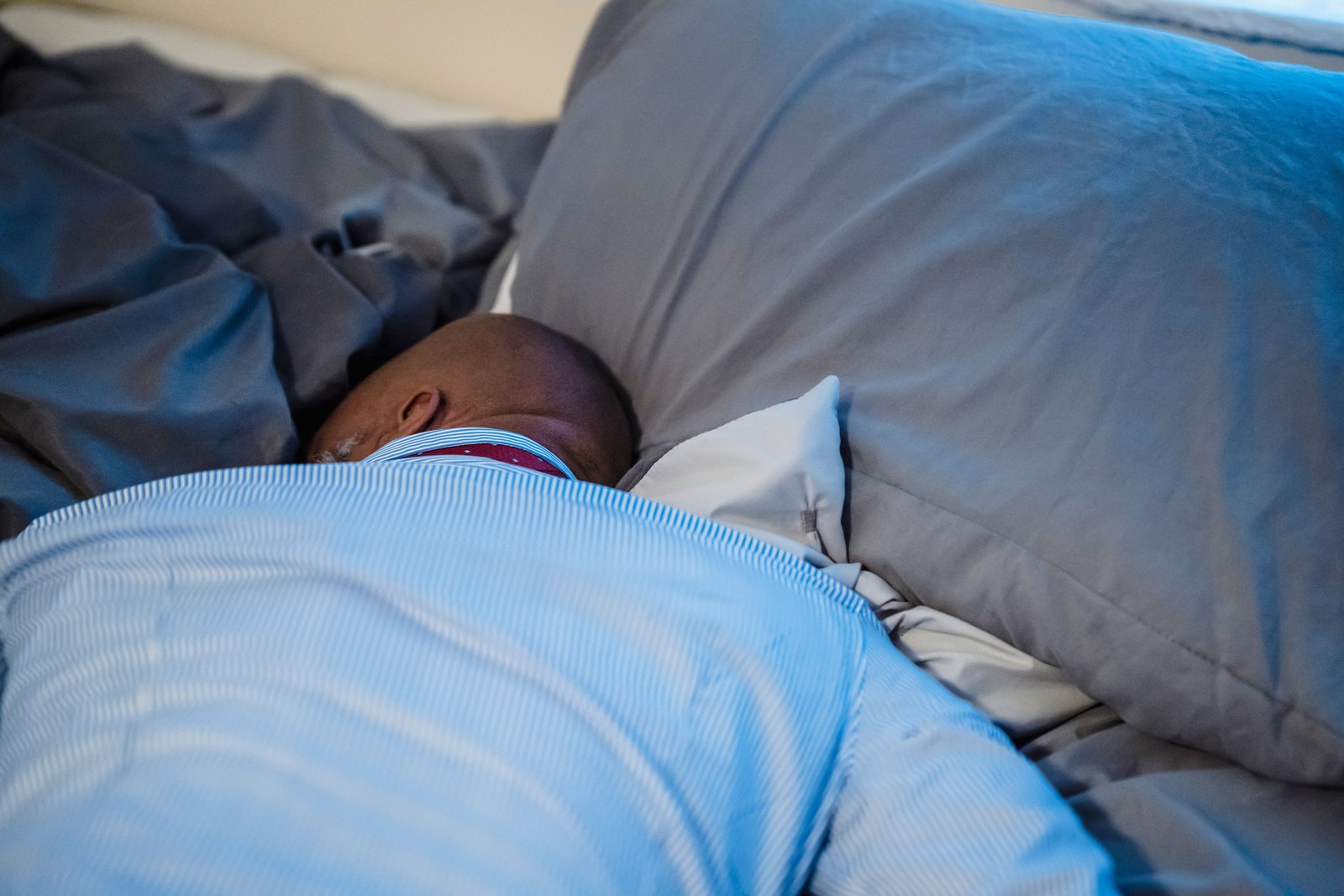 Person sleeping in a supportive position relevant to rhomboid pain sleeping position
