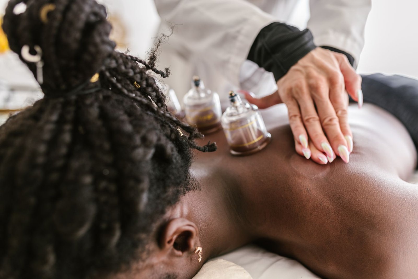 Therapist performing cupping therapy on a client's back, showing the purpose of cupping in a sports recovery setting