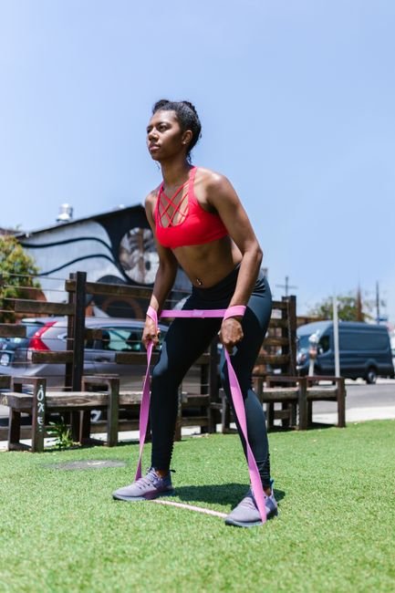 Person performing resistance band shoulder blade strengthening as part of middle back pain exercises