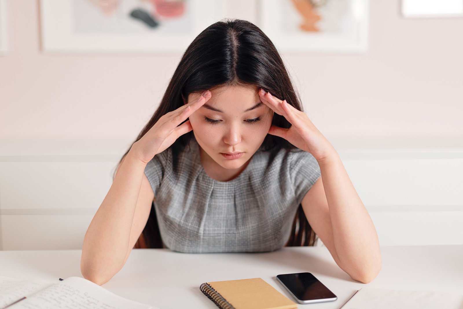 Person experiencing pain on top of skull at their desk