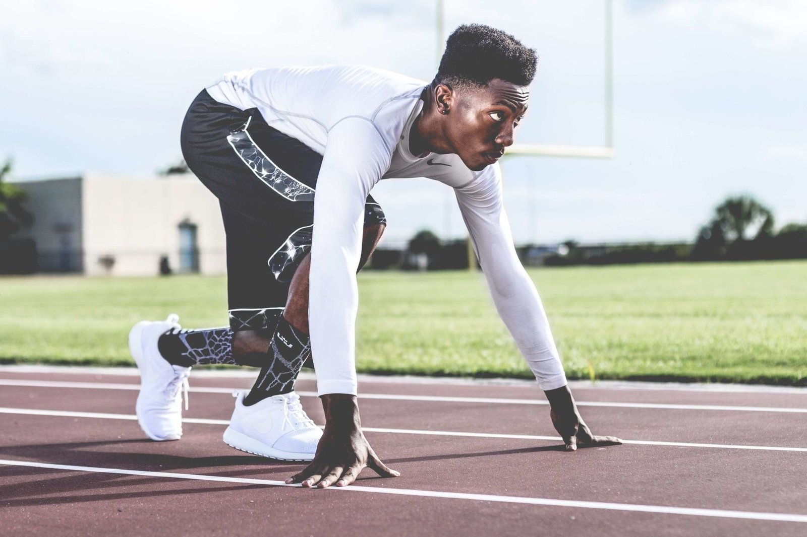 Athlete in a sprint starting position, illustrating the final sprint-mechanics stage of hamstring rehab exercises