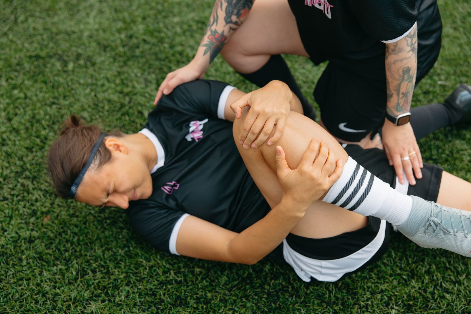 Athlete holding an injured outer knee on the field, illustrating common lcl injury symptoms