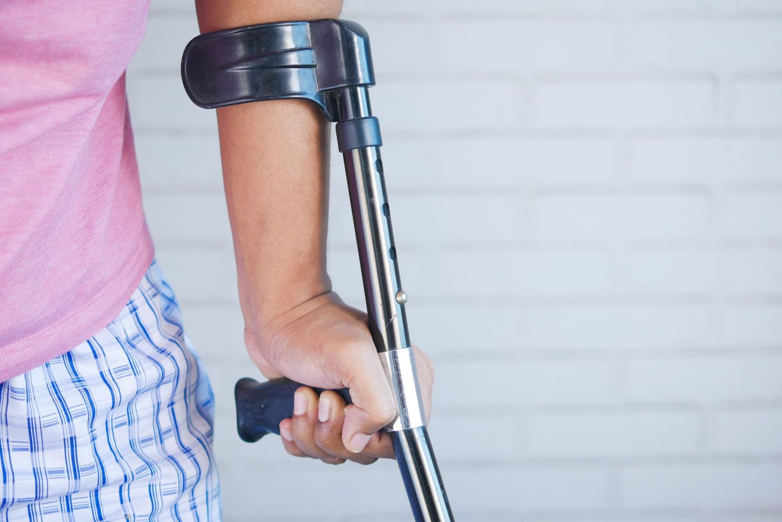 Person using crutches indoors, part of the early phase covered in these broken ankle recovery tips