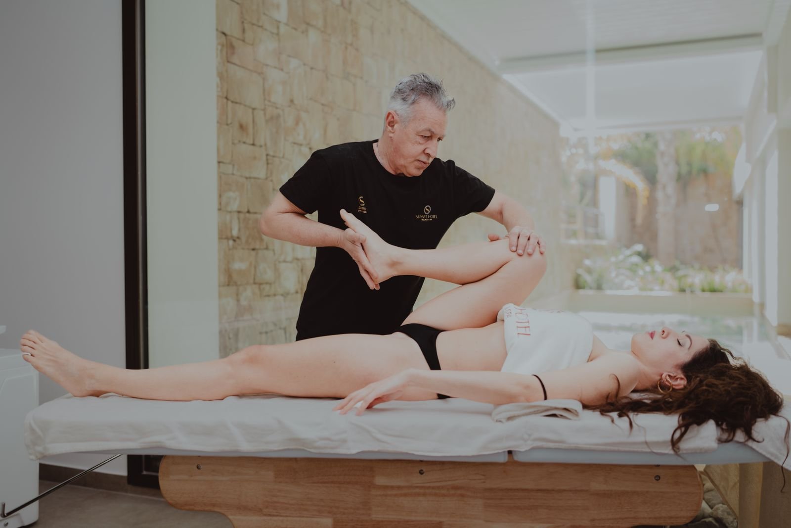 A therapist assessing hip strength to guide the next stage of hip flexor rehab exercises.