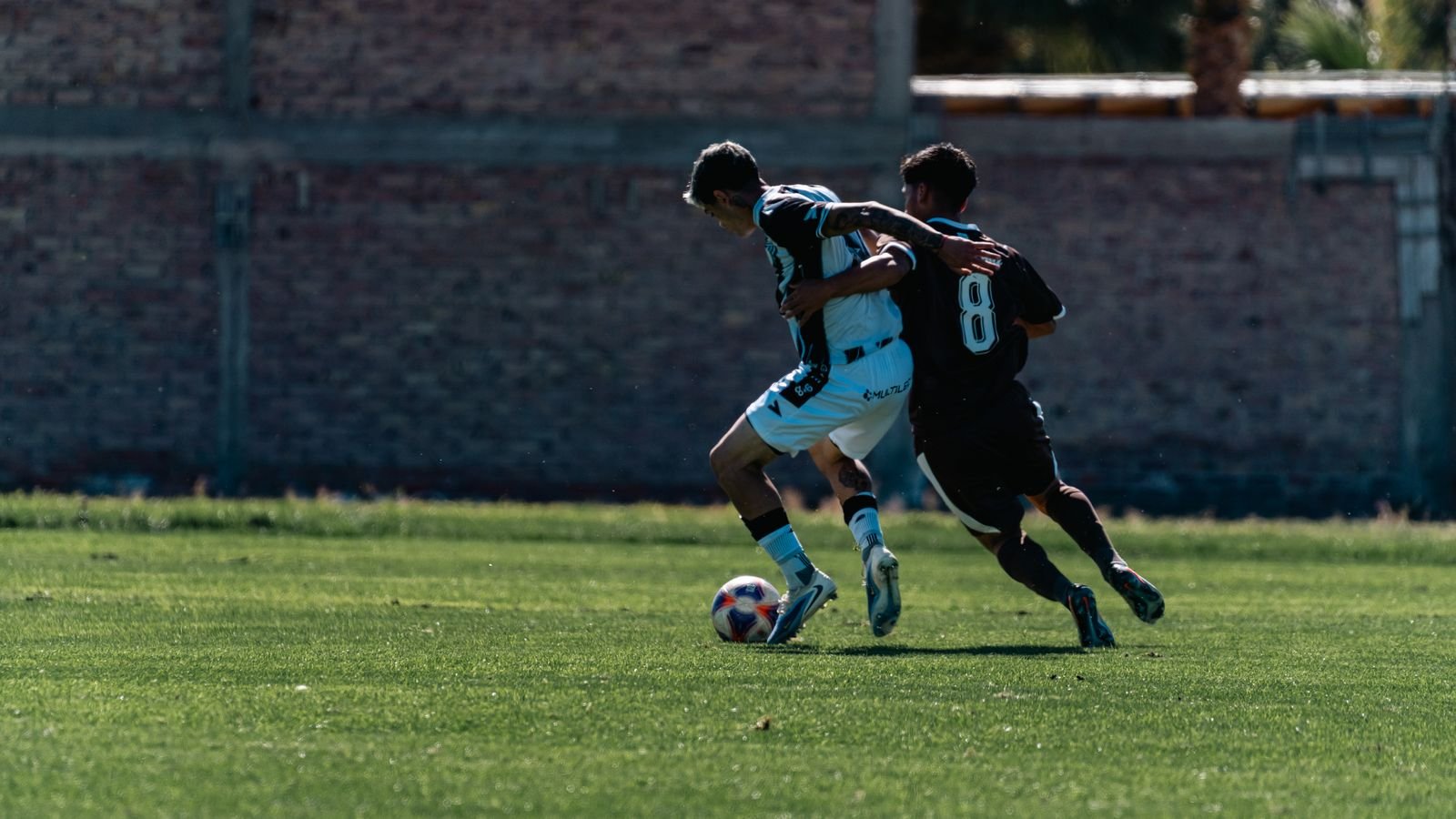 Two football players competing for the ball, the kind of contact that explains why the MCL meaning matters in sport.