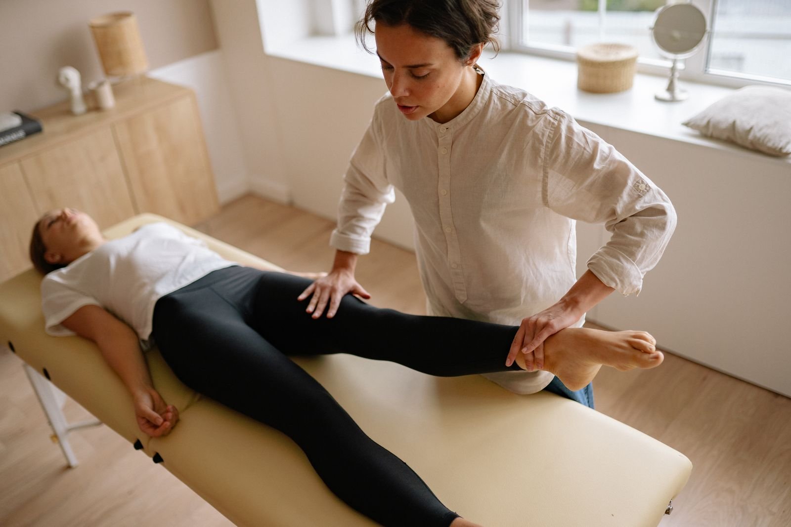 A therapist assessing a runner's lower leg strength before recommending exercises to prevent shin splints.