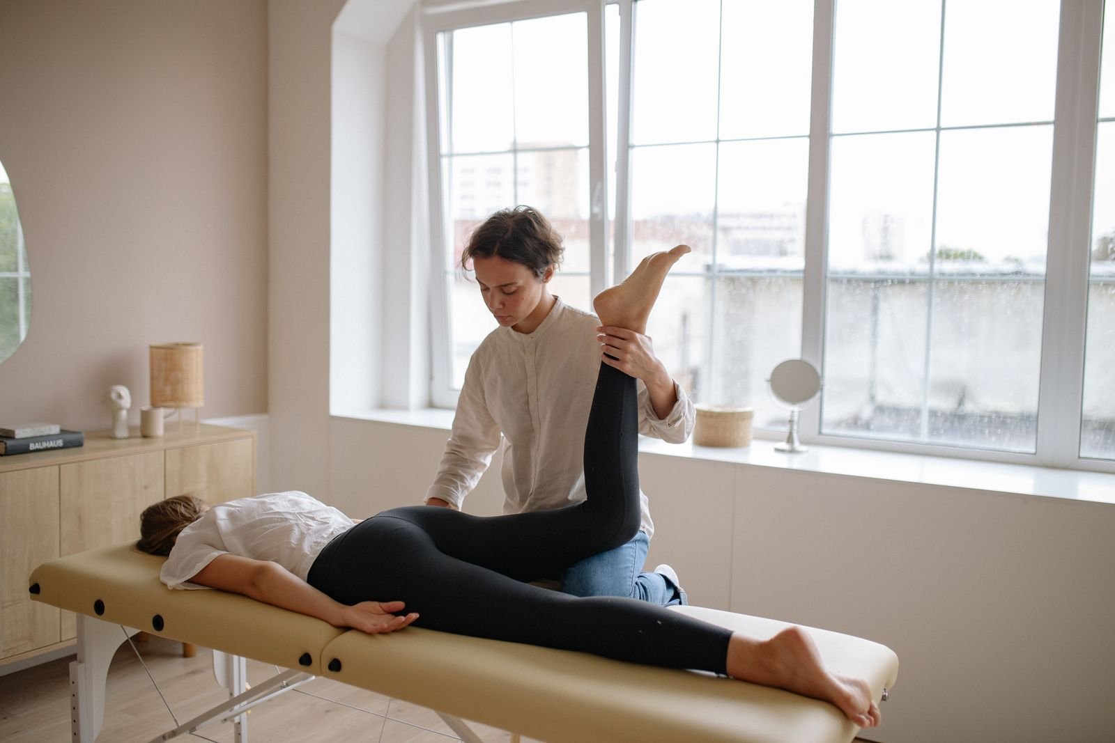A therapist assessing a runner's hip movement to find the cause of groin pain running.